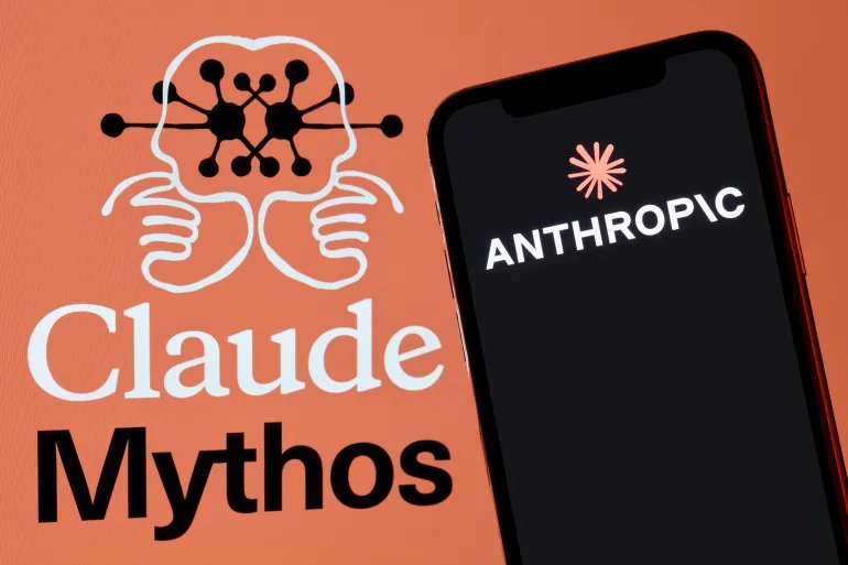 A red-framed smartphone displaying the Anthropic corporate logo is positioned in front of an orange background featuring the Claude Mythos product branding alongside a symmetrical illustration depicting two human brain or face profiles joined and interconnected by a neural network diagram in San Ferdinando di Puglia, Italy, on May 17, 2026. The Claude Mythos wordmark appears below in white and black serif typography. The composition represents Anthropic's visual identity for its expanded AI product portfolio. (Photo Illustration by Matteo Della Torre/NurPhoto via Getty Images)