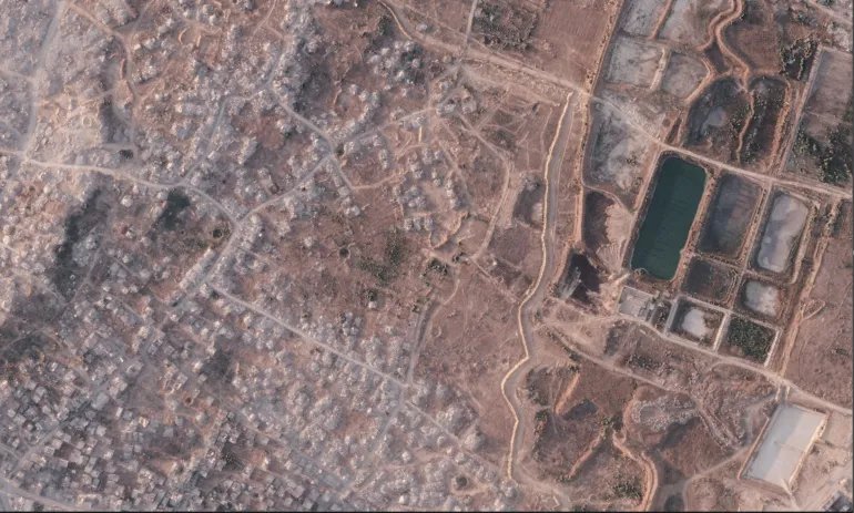 This satellite image from Planet Labs PBC shows a section of an earthen barrier being built by the Israeli military in the northern Gaza Strip, July 8, 2026. To the left is the demolished town of Beit Lahia, and at right a defunct sewage treatment plant. (Planet Labs PBC via AP)