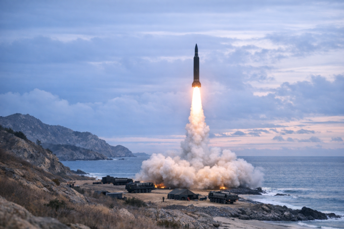 Missile launches from rocky coast beside the ocean
